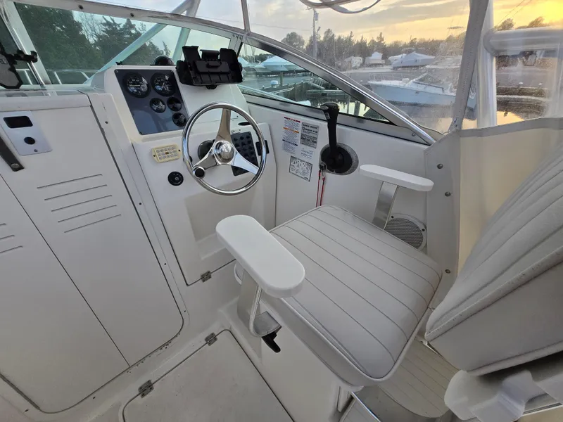 Slide: The Image of 2004 Robalo R235 Walkaround boat interior with steering wheel and captain's chair. - 14