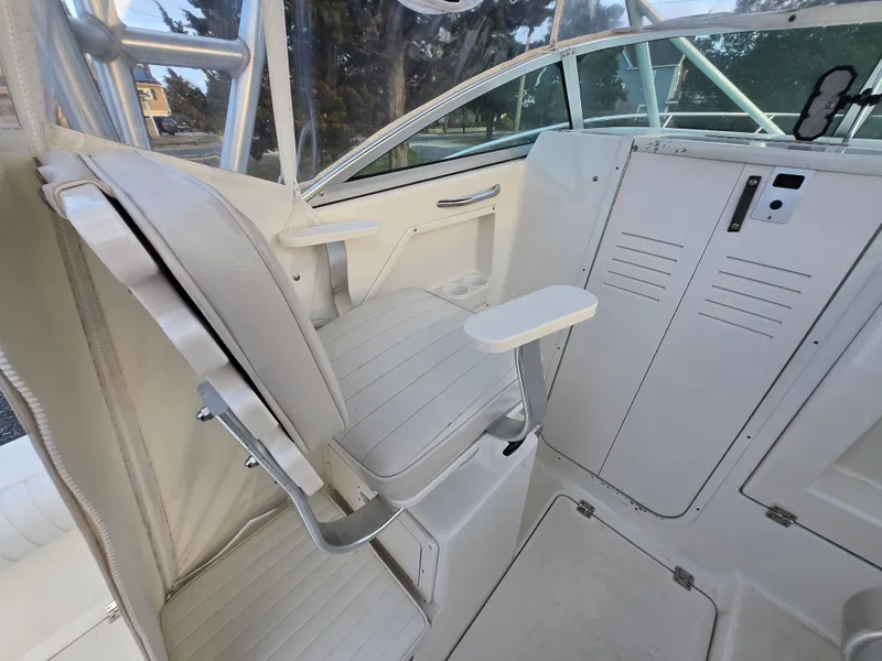 Slide: The Image of 2004 Robalo R235 Walkaround boat interior with white seating and control panel. - 15