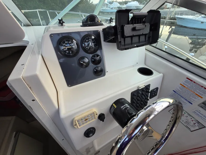 Slide: The Image of 2004 Robalo R235 Walkaround boat dashboard with gauges and steering wheel. - 16