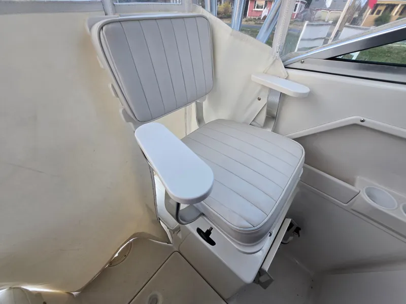 Slide: The Image of 2004 Robalo R235 Walkaround boat seat with white upholstery and armrests. - 17