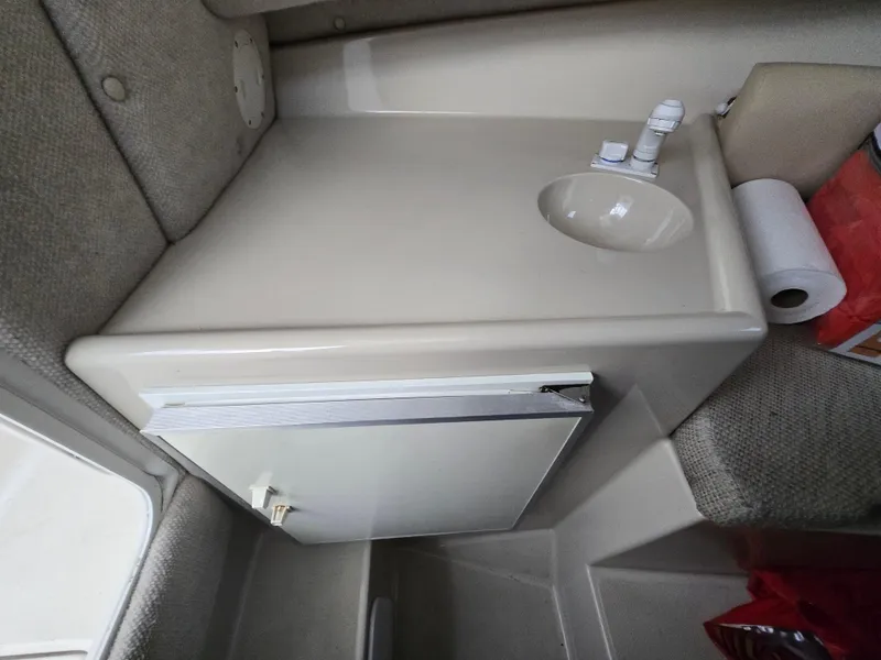 Slide: The Image of 2004 Robalo R235 Walkaround cabin interior with sink and storage. - 20