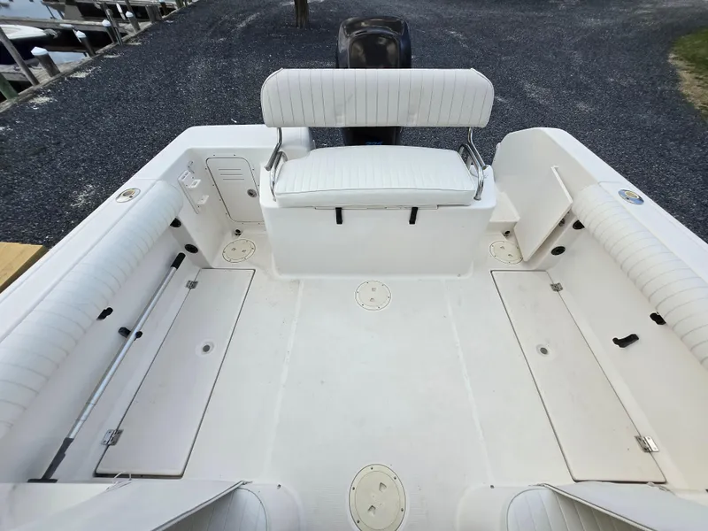 Slide: The Image of 2004 Robalo R235 Walkaround boat interior with white seating and storage compartments. - 23