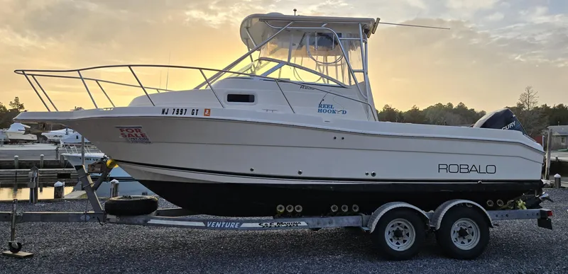 Slide: The Image of 2004 Robalo R235 Walkaround boat on trailer at sunset, for sale. - 8