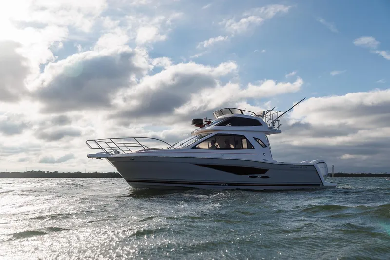 Slide: The Image of 2026 Solara S-310 SB boat cruising on open water under a cloudy sky. - 6