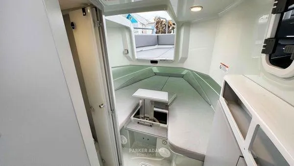 Slide: The Image of 2024 XO Boats DFNDR 9 cabin interior with seating and table. - 7