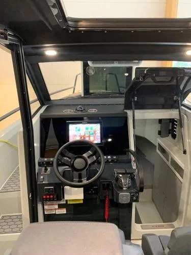 Slide: The Image of 2024 XO Boats DFNDR 9 cockpit with modern steering and navigation system. - 1