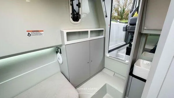 Slide: The Image of 2024 XO Boats DFNDR 9 interior with modern cabinetry and seating area. - 10