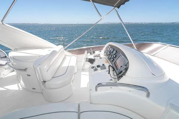 Slide: The Image of 2007 Azimut 62 yacht helm with ocean view, featuring modern controls and white seating. - 16