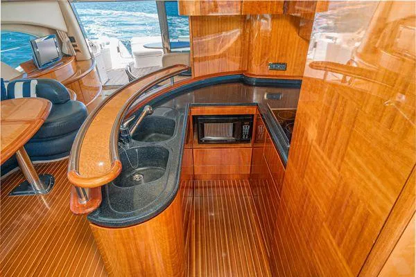 Slide: The Image of Luxurious 2007 Azimut 62 yacht interior with elegant wood finish and modern kitchen amenities. - 33