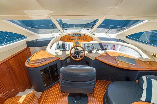Slide: The Image of 2007 Azimut 62 yacht helm with luxurious wood finish and modern navigation controls. - 35