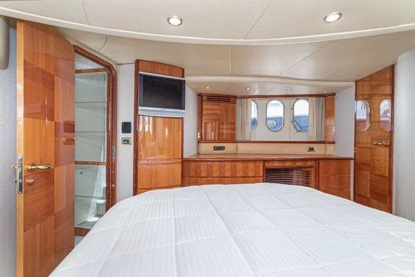 Slide: The Image of Luxurious 2007 Azimut 62 yacht bedroom with wood paneling and modern amenities. - 39