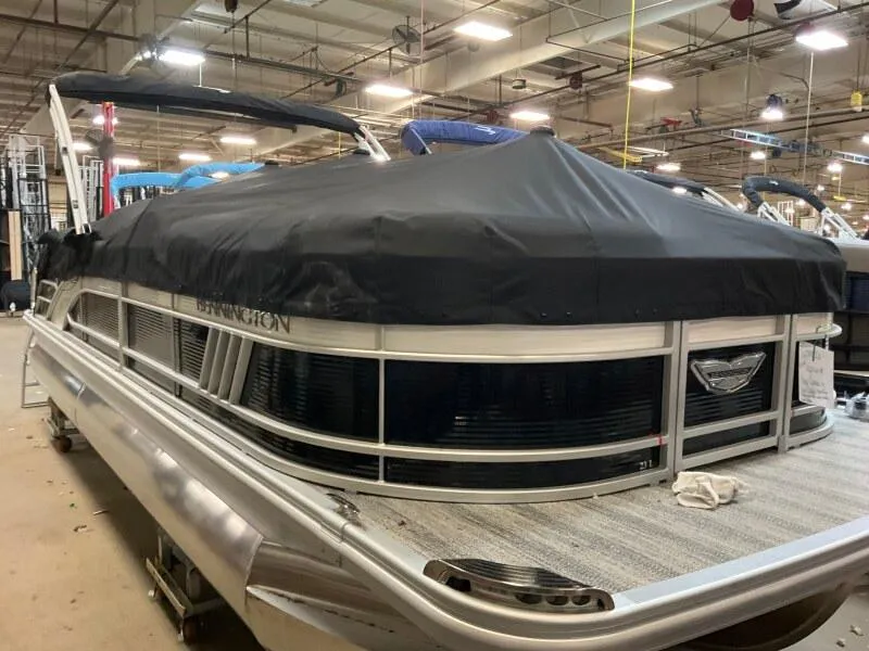 Slide: The Image of 2025 Bennington 23LFB pontoon boat with cover in a showroom setting. - 6