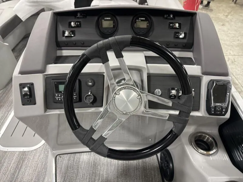 Slide: The Image of Steering wheel and dashboard of 2025 Bennington 23LFB boat, featuring modern controls and gauges. - 9