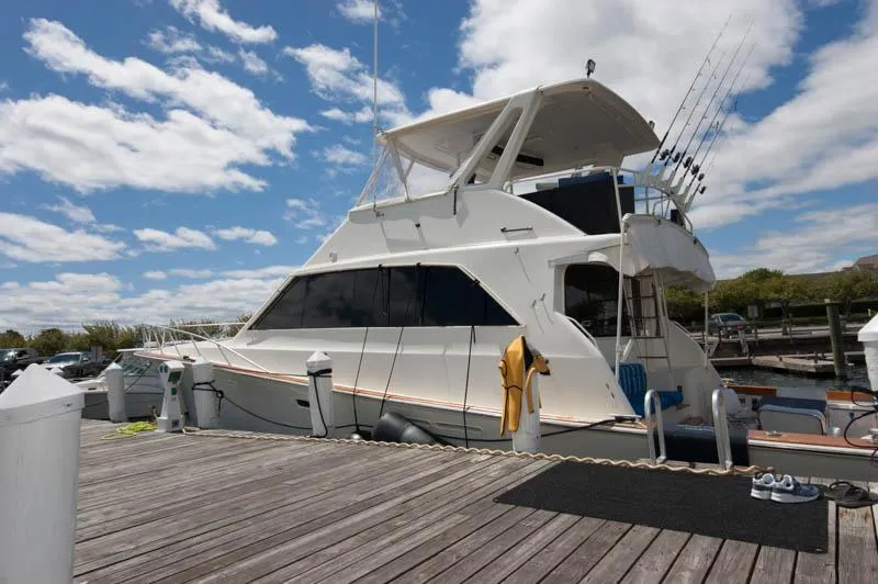 Slide: The Image of 1991 Ocean Yachts 58 Super Sport docked under a partly cloudy sky. - 3