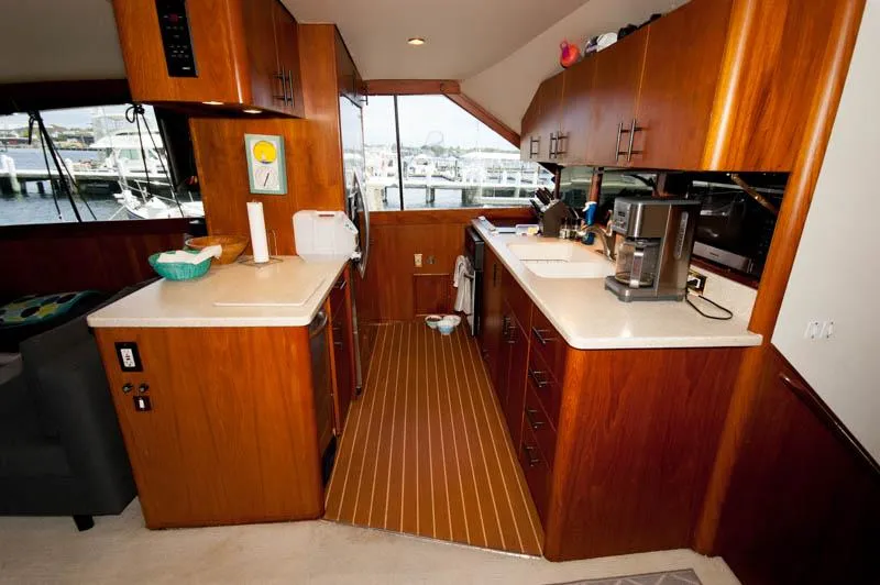 Slide: The Image of Luxurious kitchen interior of 1991 Ocean Yachts 58 Super Sport with wood cabinetry and modern appliances. - 12