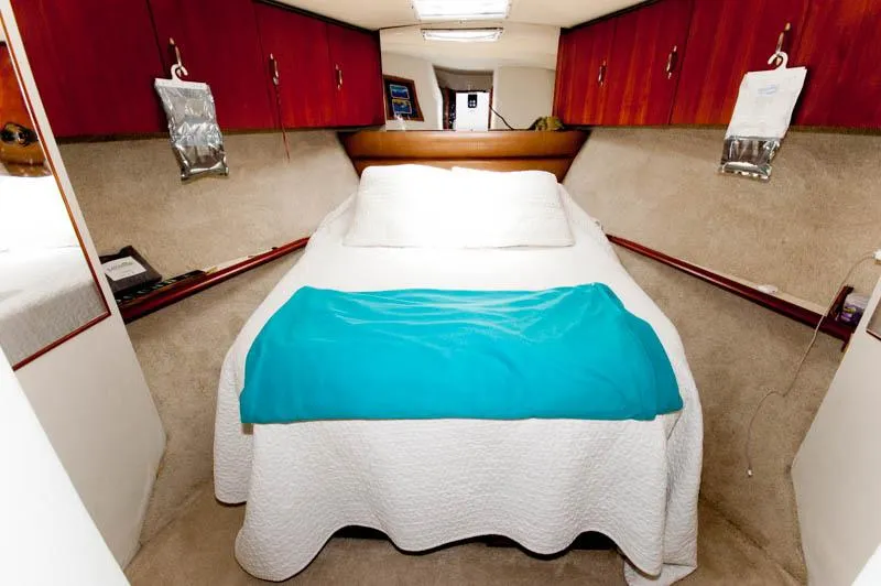 Slide: The Image of Bedroom interior of 1991 Ocean Yachts 58 Super Sport with cozy bed and wooden cabinets. - 16