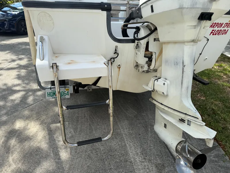 Slide: The Image of 1996 Boston Whaler Outrage 17 boat stern with ladder and outboard motor. - 13