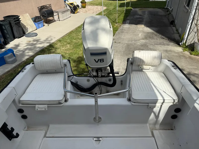Slide: The Image of 1996 Boston Whaler Outrage 17 boat interior with V6 engine and white seating. - 16
