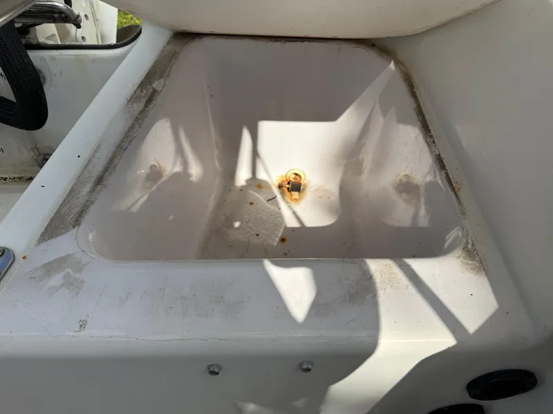 Slide: The Image of 1996 Boston Whaler Outrage 17 boat interior detail with visible wear and drain plug. - 21