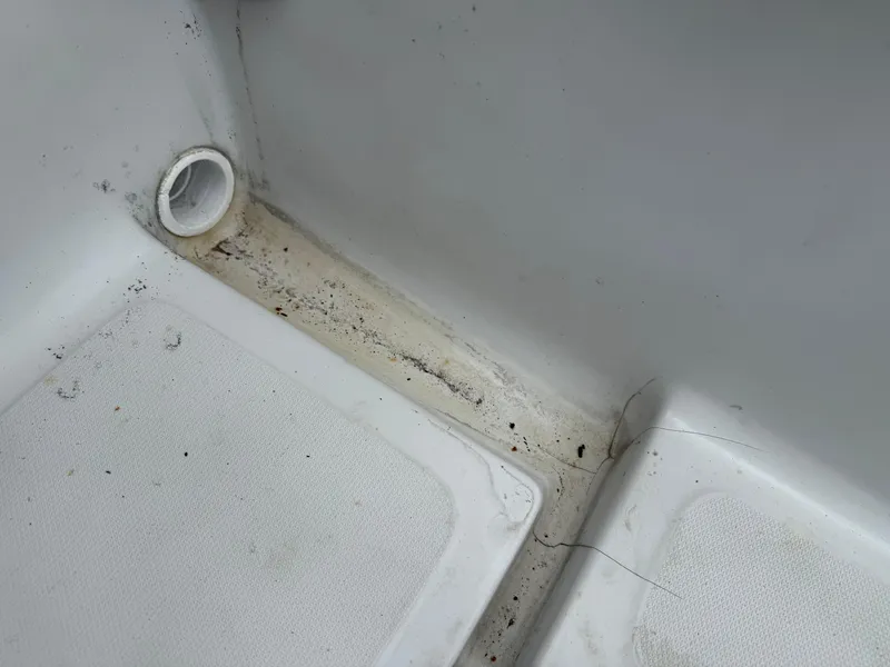 Slide: The Image of Interior detail of a 1996 Boston Whaler Outrage 17 boat, showing a drain area. - 22