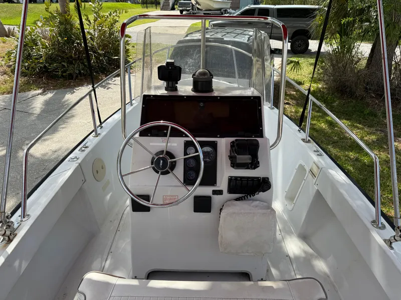 Slide: The Image of 1996 Boston Whaler Outrage 17 boat cockpit with steering wheel and control panel. - 23