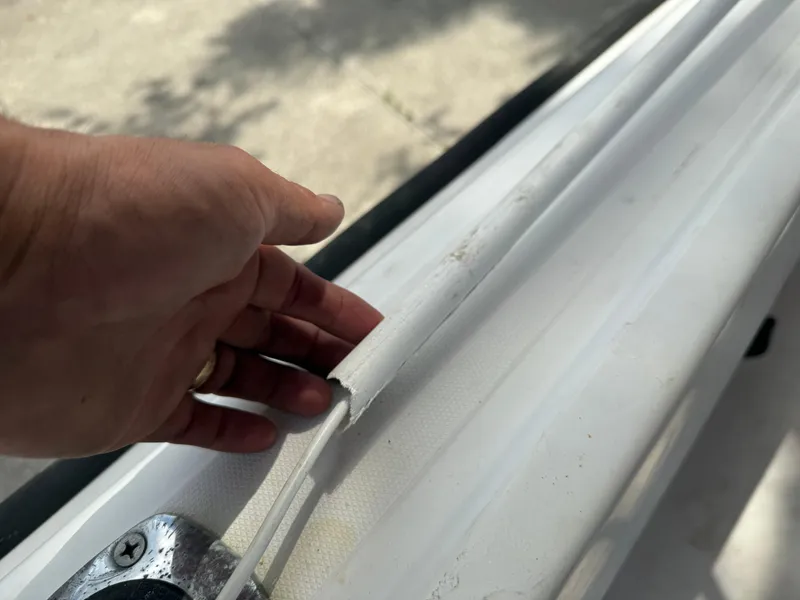 Slide: The Image of Hand inspecting the edge of a 1996 Boston Whaler Outrage 17 boat. - 25