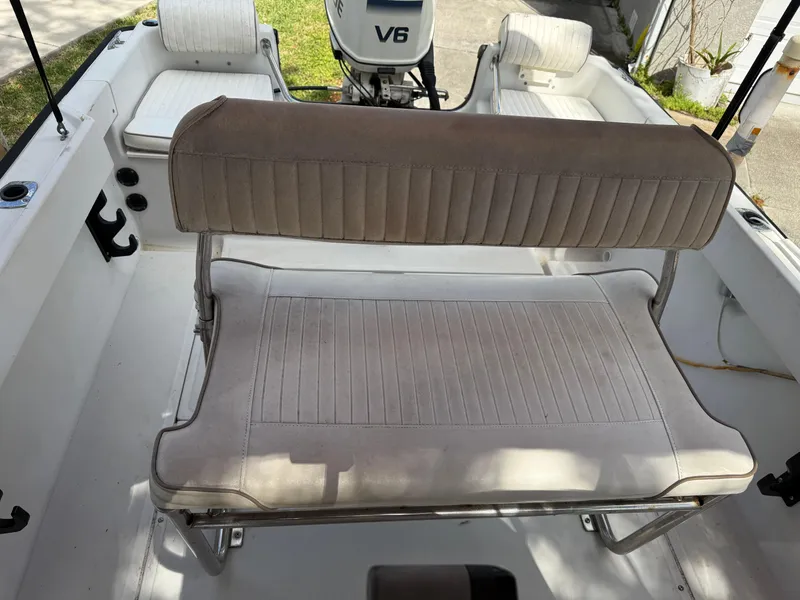 Slide: The Image of 1996 Boston Whaler Outrage 17 boat interior with seating and V6 engine. - 27