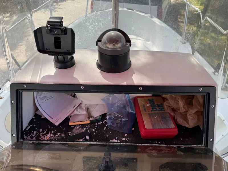 Slide: The Image of 1996 Boston Whaler Outrage 17 console with storage, papers, and navigation equipment. - 31