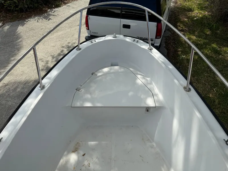 Slide: The Image of 1996 Boston Whaler Outrage 17 boat bow with railing, parked near a white truck. - 42