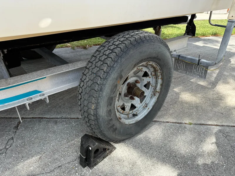 Slide: The Image of Trailer wheel of a 1996 Boston Whaler Outrage 17 boat, secured with a chock. - 8