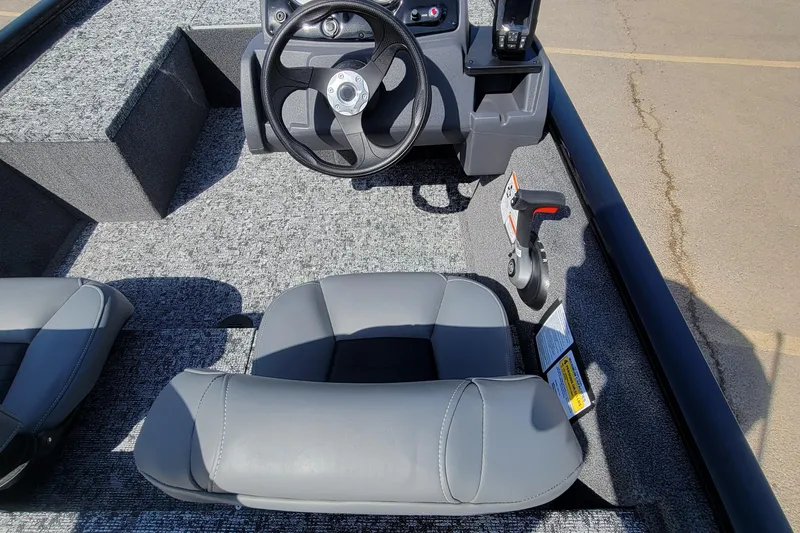 Slide: The Image of 2025 Tracker Pro 170 boat interior with steering wheel and gray seating. - 4