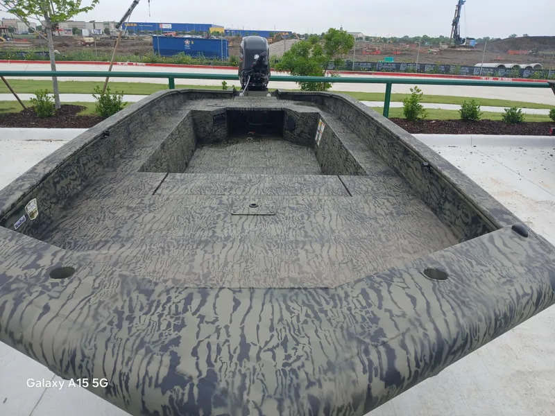 Slide: The Image of 2025 Tracker Grizzly 1650 T Prairie Wings Edition boat with camouflage design, parked outdoors. - 5