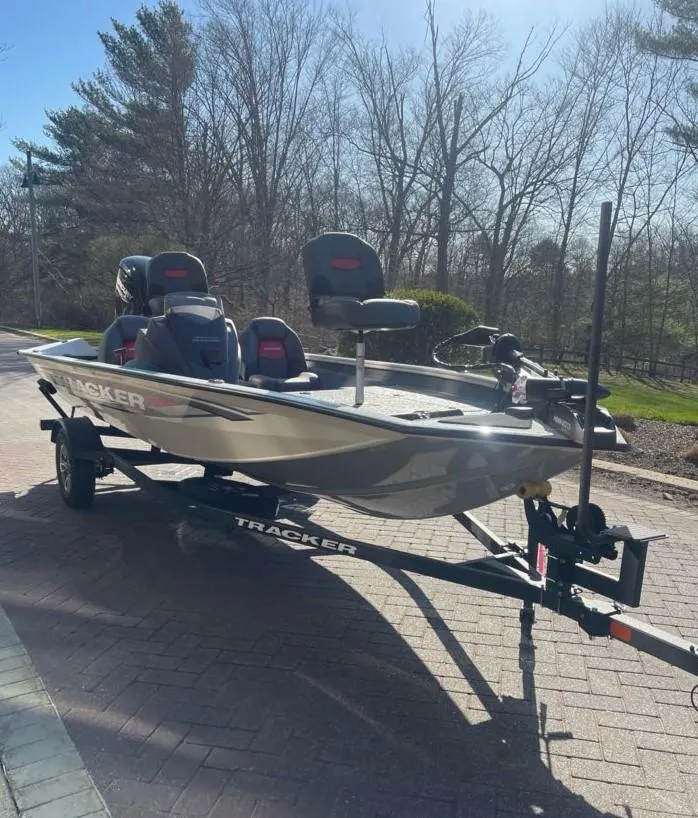 Slide: The Image of 2025 Tracker Pro Team 175 boat on trailer, parked outdoors on a sunny day. - 2