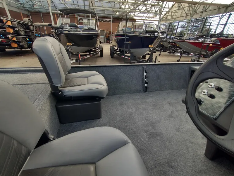 Slide: The Image of 2025 Tracker Bass Tracker Classic XL interior with gray seating in a showroom. - 7