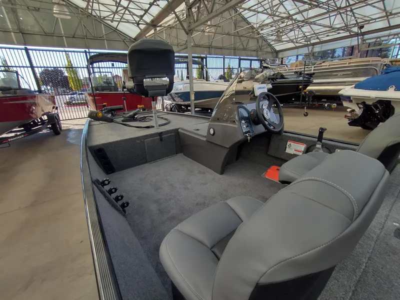 Slide: The Image of 2025 Tracker Bass Tracker Classic XL boat interior in showroom, featuring seating and steering console. - 8