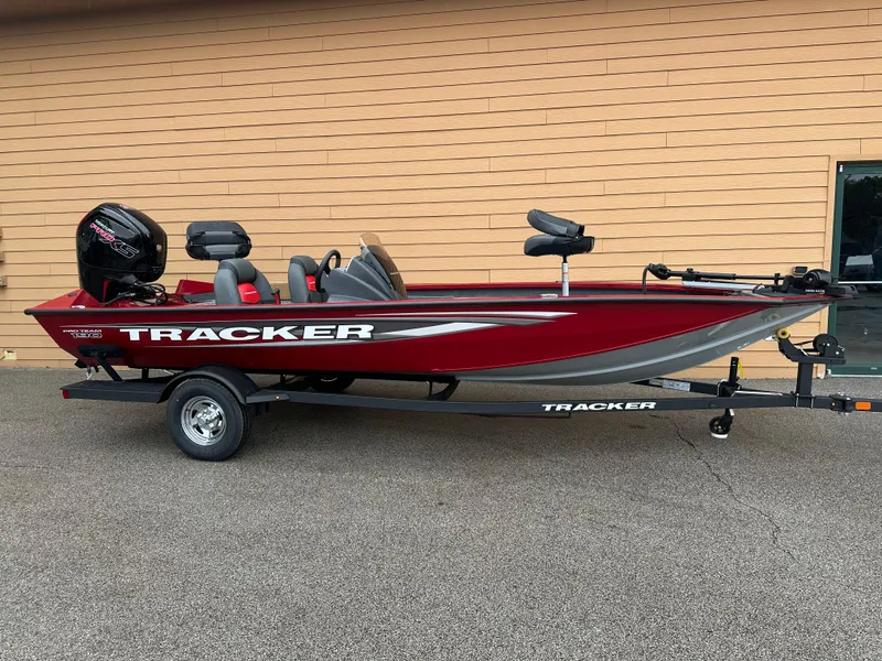 The Image of 2025 Tracker Pro Team 190 boat, red and gray, on a trailer, parked outdoors. - 0