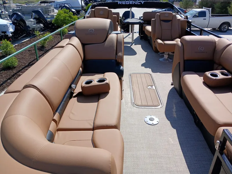 Slide: The Image of Luxurious 2025 Regency 230 LE3 pontoon boat with spacious tan seating and cup holders. - 10