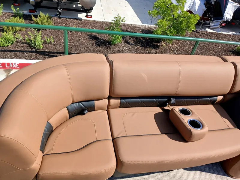 Slide: The Image of Luxurious seating on 2025 Regency 230 LE3 boat with cup holders, tan and black upholstery. - 12