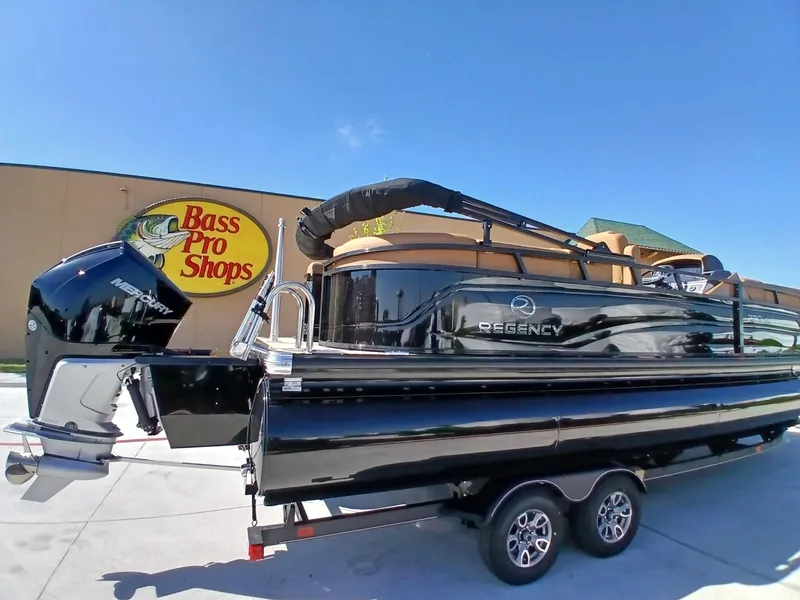 Slide: The Image of 2025 Regency 230 LE3 boat on trailer outside Bass Pro Shops. - 4