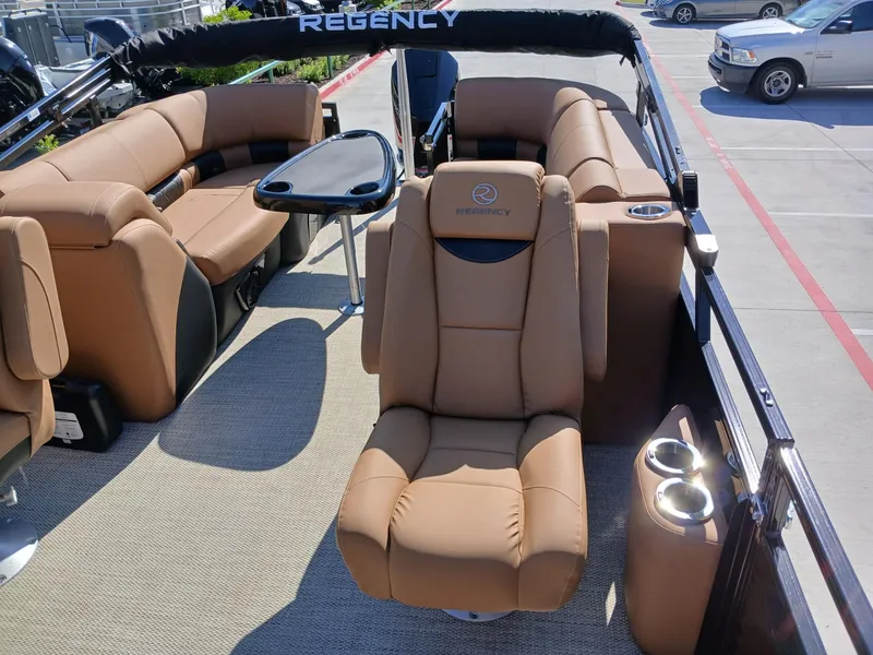 Slide: The Image of 2025 Regency 230 LE3 pontoon boat interior with luxurious tan seating and table. - 8