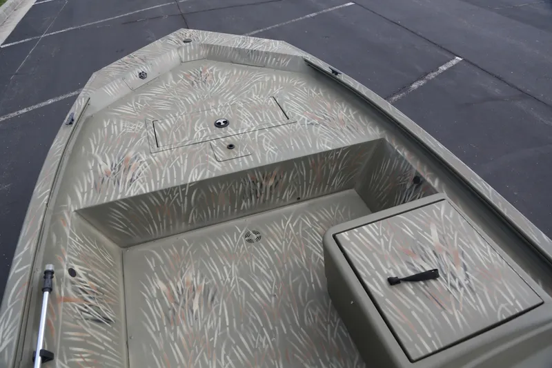 Slide: The Image of 2025 Tracker Grizzly 1648 SC boat interior with camouflage design, featuring storage compartments. - 2