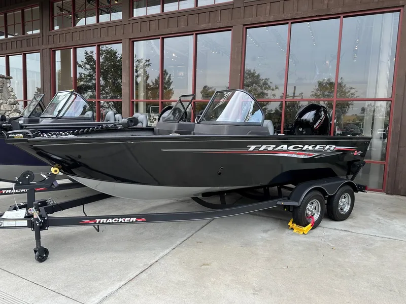 The Image of 2025 Tracker Pro Guide V-175 WT boat on trailer, parked outside a building. - 0