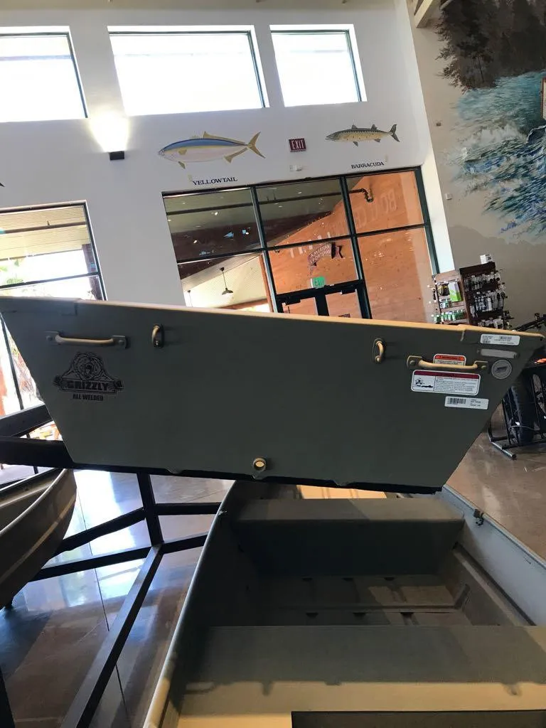 Slide: The Image of 2025 Tracker Grizzly 12 Jon boat displayed indoors with fish decor. - 2