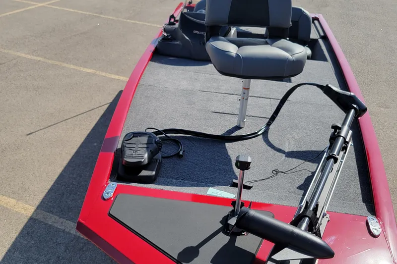 Slide: The Image of 2025 Tracker Pro 170 boat with red trim and fishing seat on deck. - 2