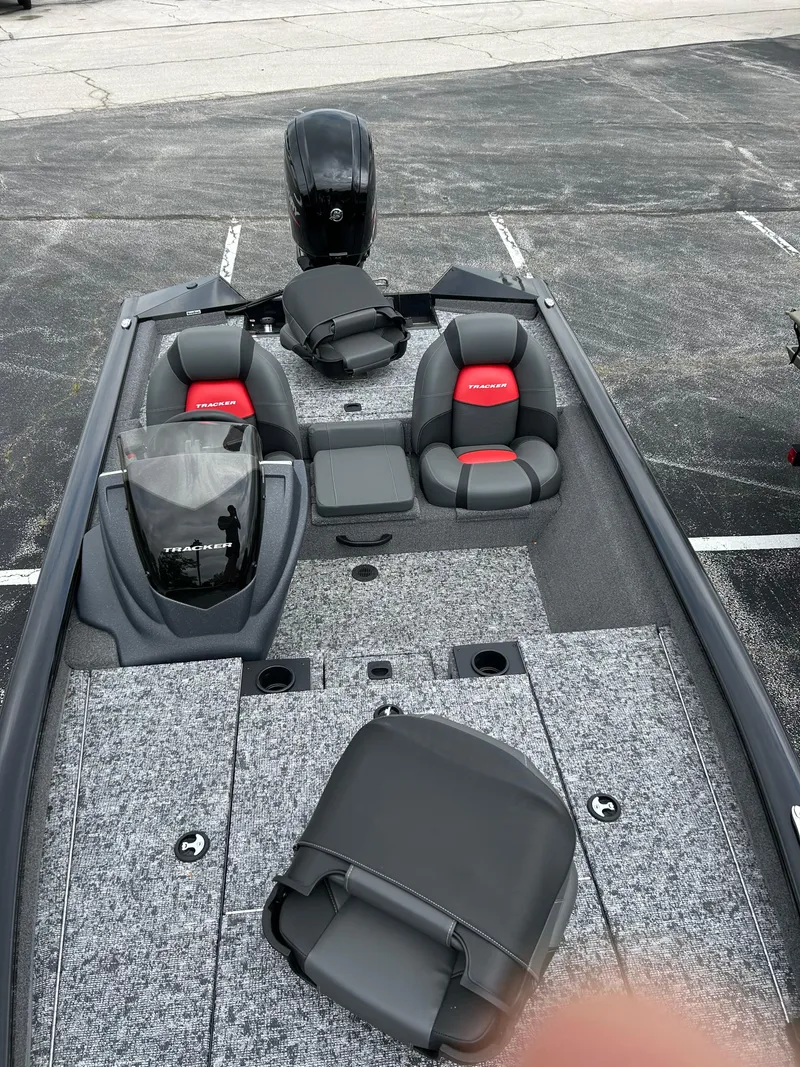Slide: The Image of 2025 Tracker Pro Team 175 boat with seating and motor in a parking lot. - 3
