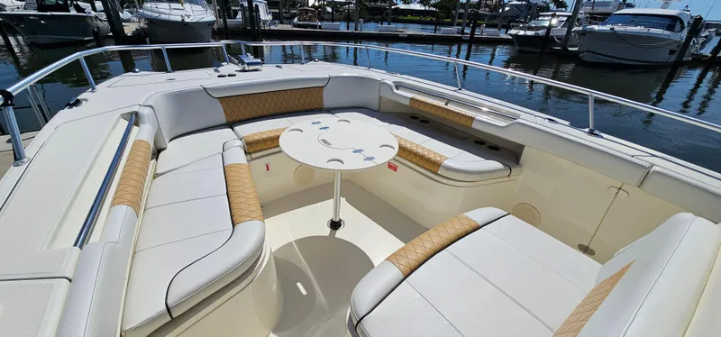 Slide: The Image of 2016 World Cat 320 boat interior with cushioned seating and table, docked at marina. - 11