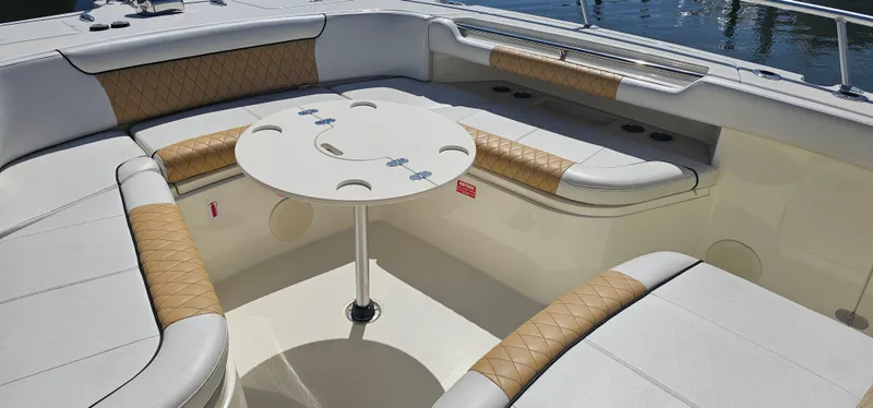 Slide: The Image of Luxurious seating area on 2016 World Cat 320 boat with round table and cushioned seats. - 12