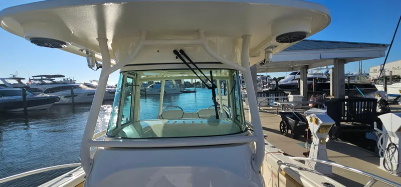 Slide: The Image of 2016 World Cat 320 boat docked at marina, surrounded by other vessels under clear blue sky. - 2