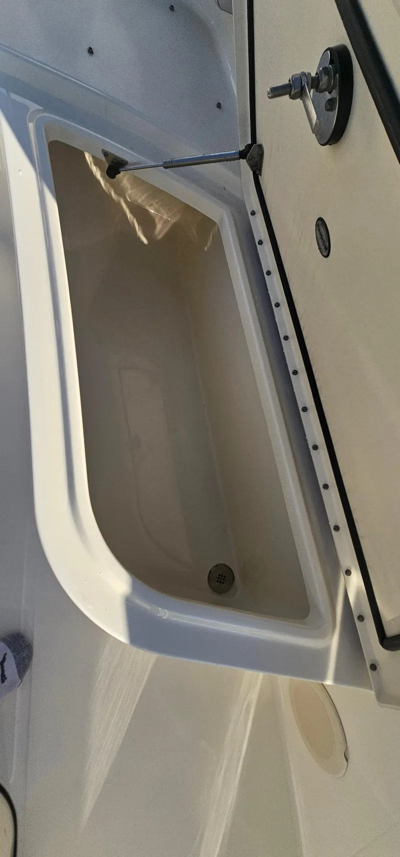 Slide: The Image of 2016 World Cat 320 boat storage compartment with open lid. - 21