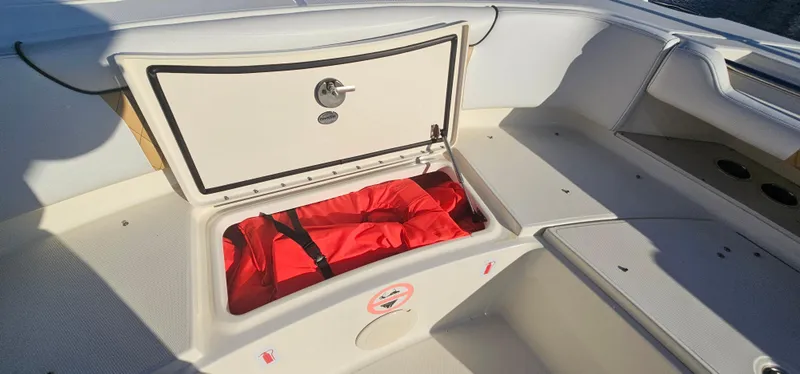 Slide: The Image of 2016 World Cat 320 boat storage compartment with red life jackets inside. - 22